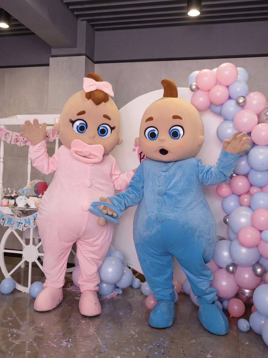 Baby-Maskottchen mit Ballons in Rosa und Blau